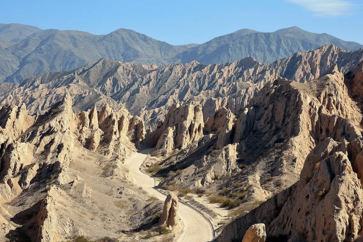 Een onverharde weg slingert door de spectaculaire, puntige rotsformaties van de Quebrada de las Flechas in de provincie Salta.