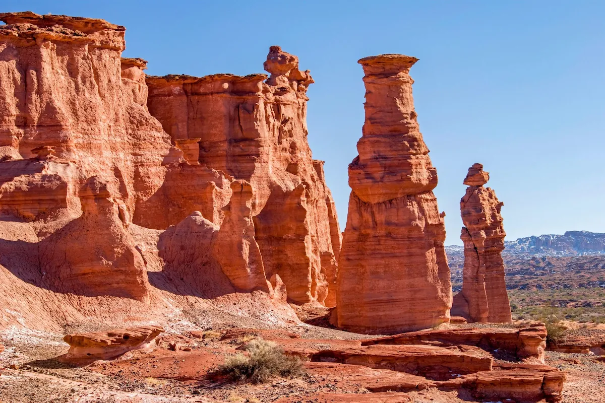 Imposante, torenhoge rode zandsteenformaties en kloofwanden in het Nationaal Park Talampaya in Argentinië onder een helderblauwe lucht.