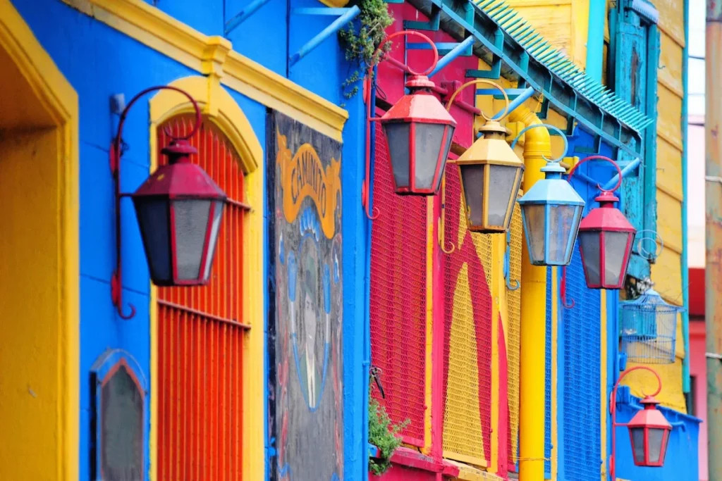 Kleurrijke lantaarns aan de felgeblauw en geel geschilderde muren van de Caminito in de wijk La Boca, Buenos Aires.
