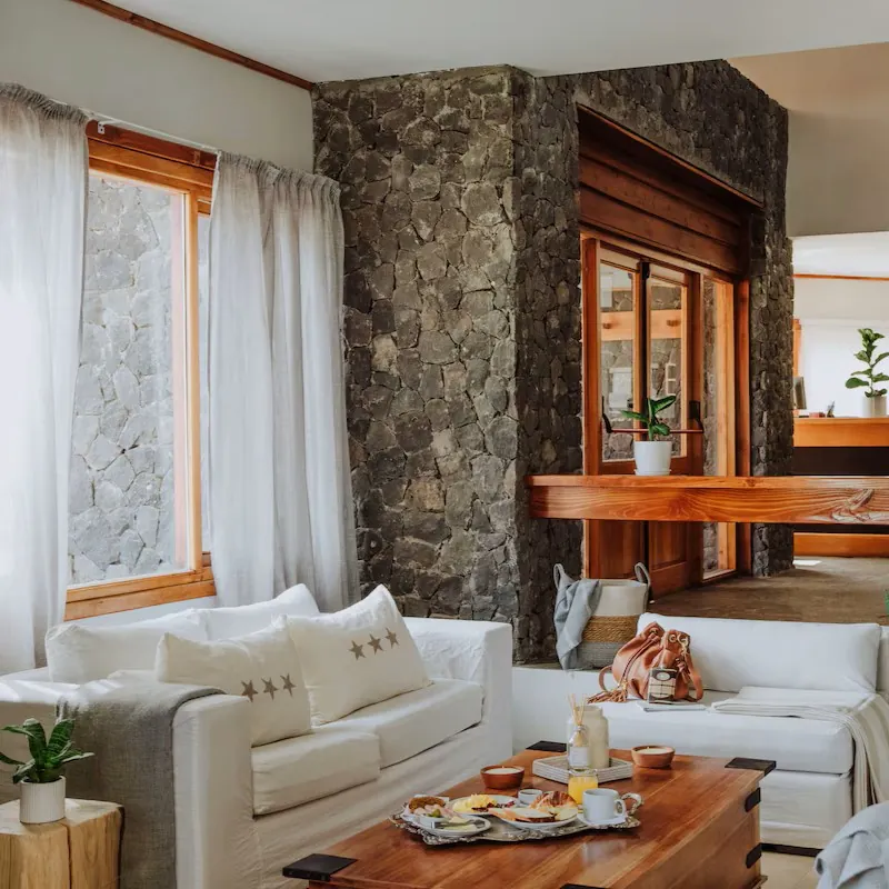 Het sfeervolle interieur van Hostería El Coirón in Esquel, met natuurstenen muren, houten accenten en een gezellige zithoek.