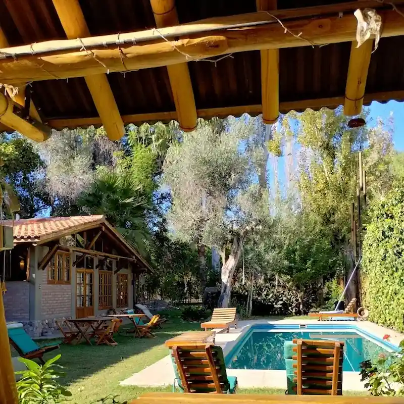 Rustieke stenen gevel en buitenzwembad van Hotel Rústico Cerro del Valle in San Agustín de Valle Fértil.
