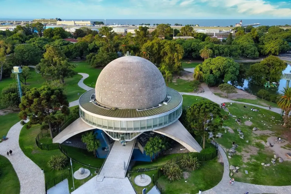 Een luchtfoto van het iconische Planetario Galileo Galilei in de parken van Palermo, Buenos Aires, onder een blauwe lucht met witte wolken.