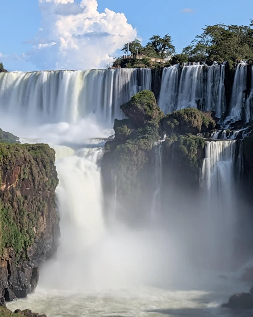 Krachtige gelaagde watervallen van Iguazú met een uitzichtplatform op de groene rotsen aan de Argentijnse kant.