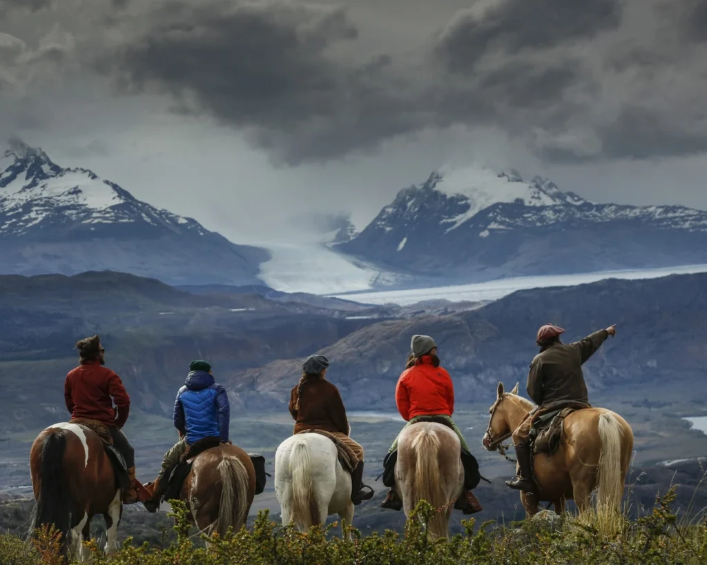 Reizigers maken een paardrijdtocht bij Estancia Cristina met uitzicht op de Upsala gletsjer nabij El Calafate, Patagonië.